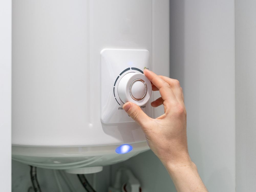 A person adjusting their water heater temperature