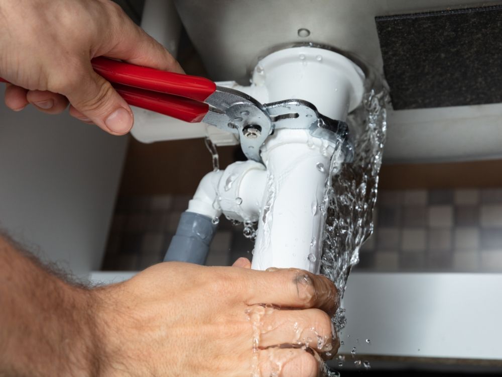 A plumber fixing a leaky pipe