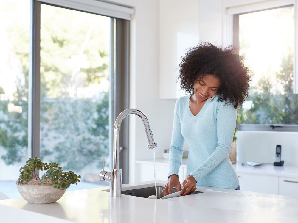 Woman doing dishes in sink