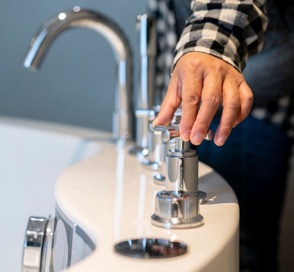 A plumber testing a tub faucet