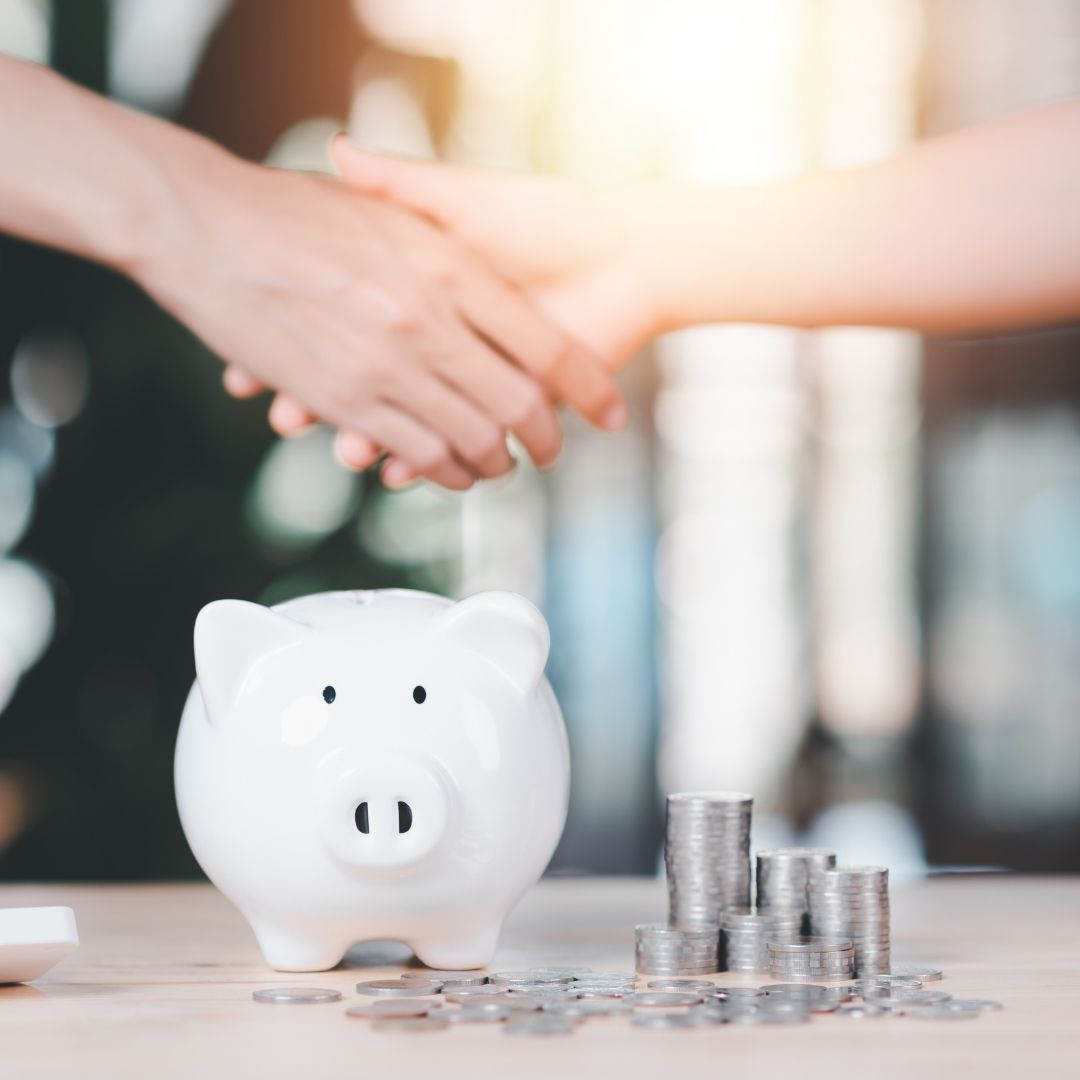 Piggy bank in front of a handshake