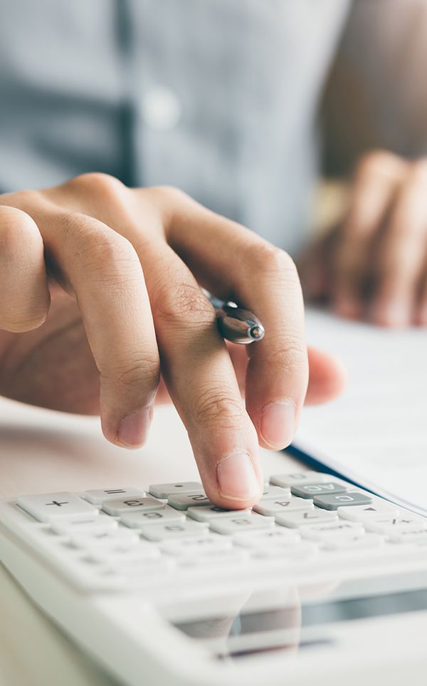 Image of a hand typing on a calculator