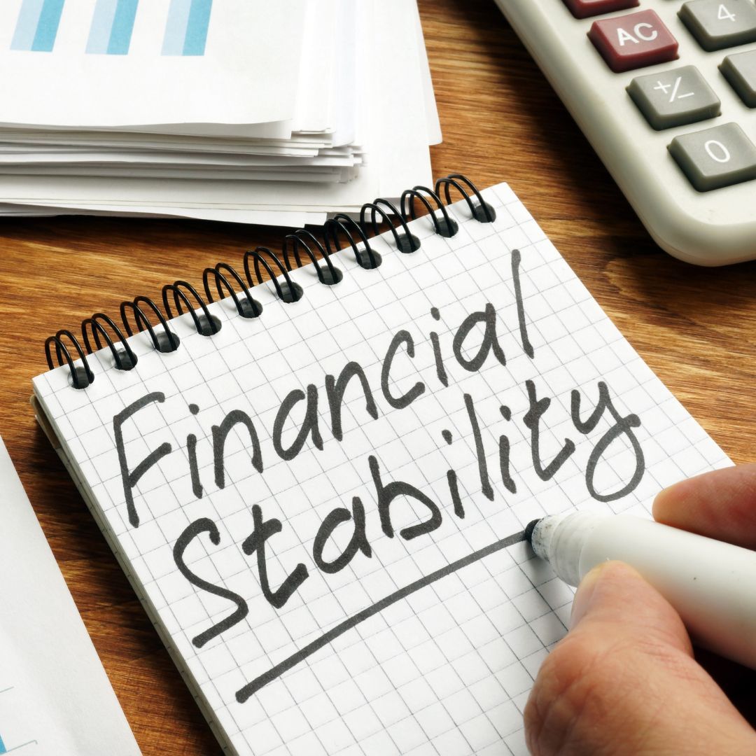 Notebook reading "Financial Stability" in black marker