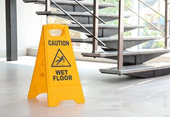 A wet floor sign positioned by stairs