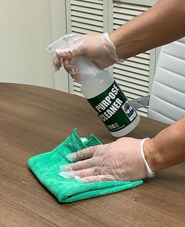 Closeup of technician cleaning a surface with all purpose cleaner