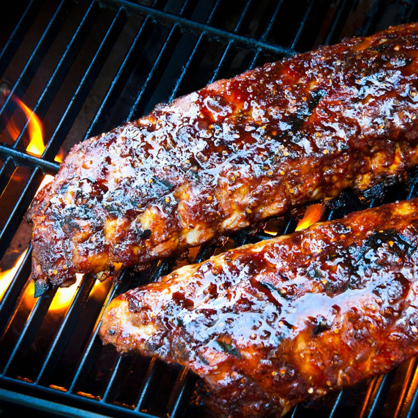 bbq ribs on a grill covered in sauce