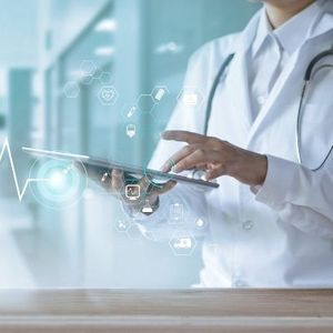 medical professional using tablet with tech icons overlaid