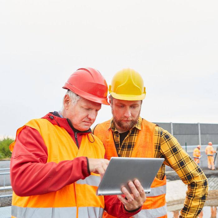 construction workers looking at tablet