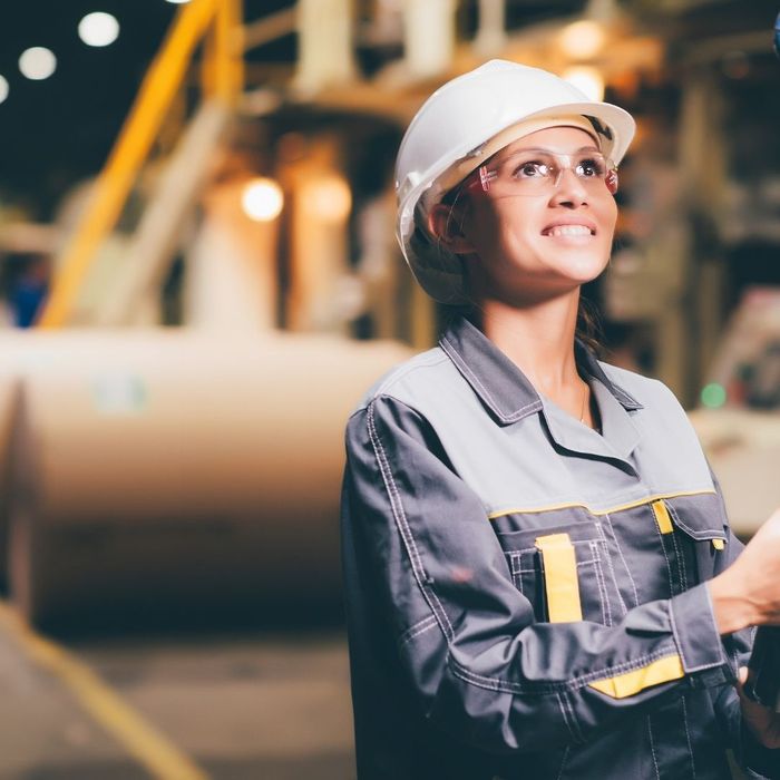Manufacturing employee looking up with hard hat on