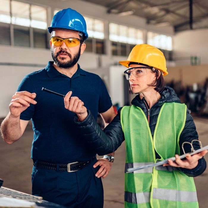 man and woman wearing hard hats and safety goggles