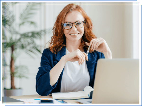 Professional woman with glasses working on laptop at desk