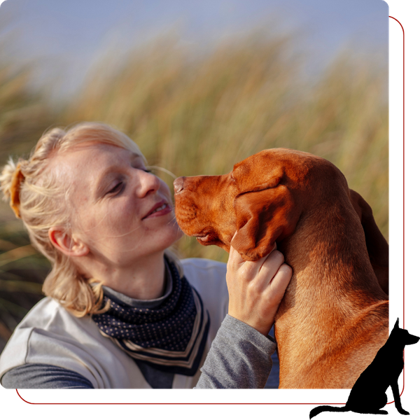 woman cuddling her dog outside