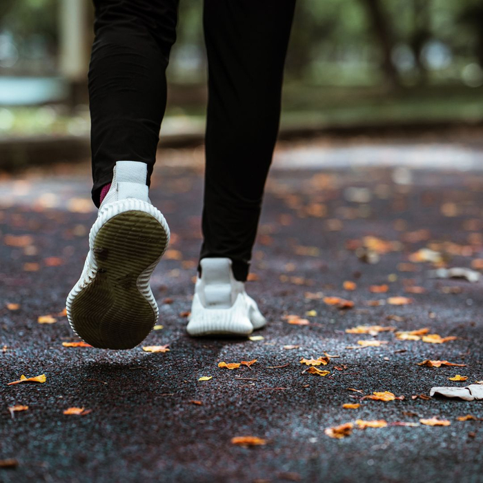 closeup of woman walking on a trail with fallen leaves closeup of woman walking on a trail with fallen leaves