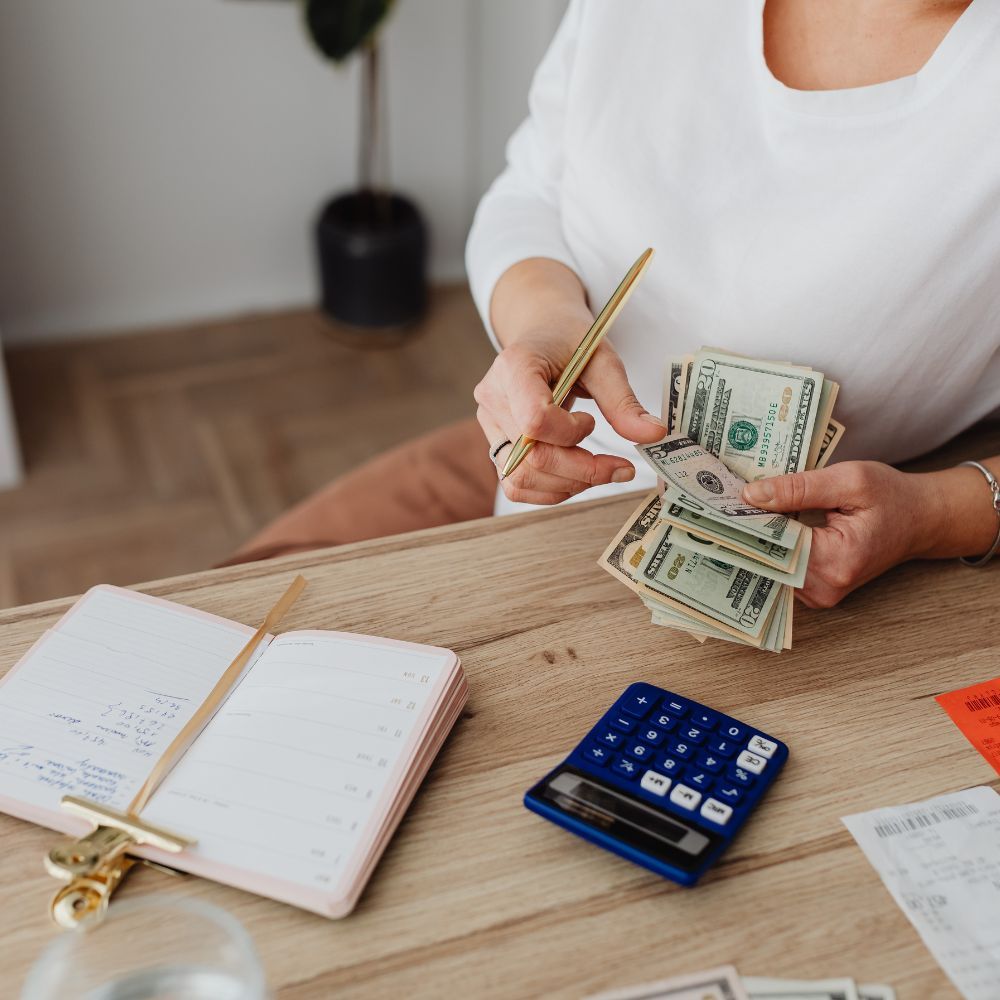 woman counting money with calculator
