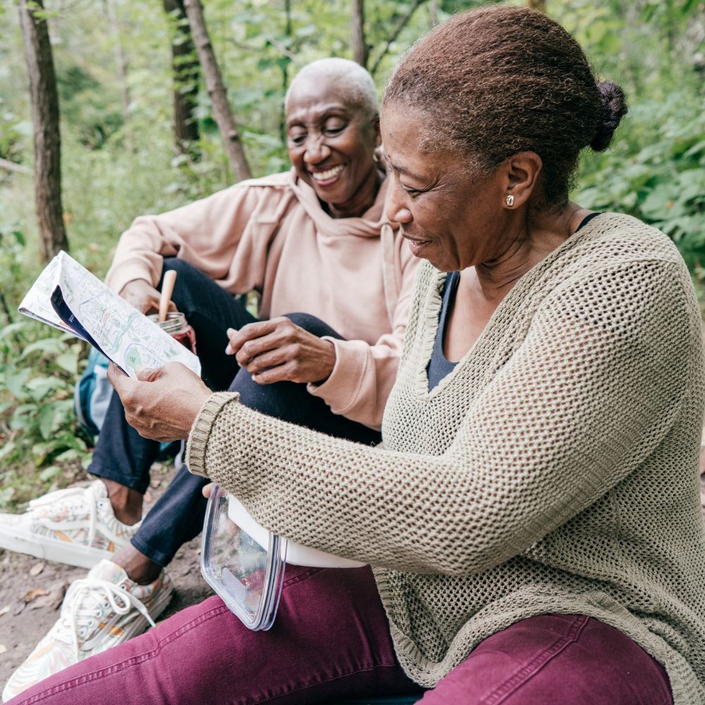 seniors looking at a map in the forest