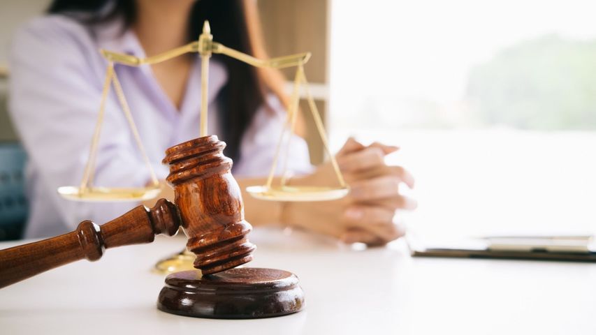 woman sitting at a table with a gavel on it