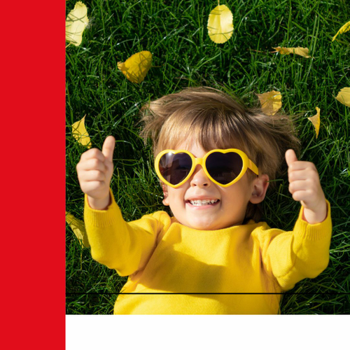 Kid giving thumbs up with leaves falling on the grass