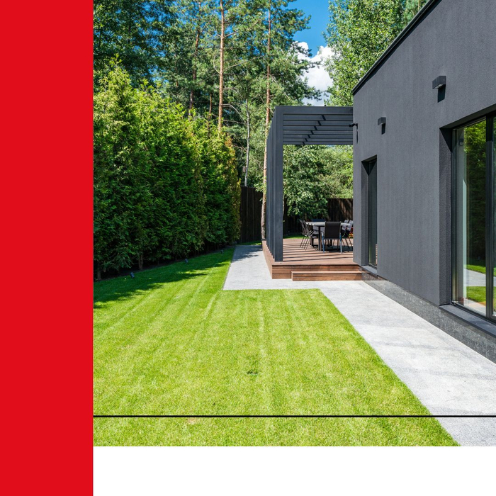 A nicely maintained sideyard with a concrete path next to a modern home