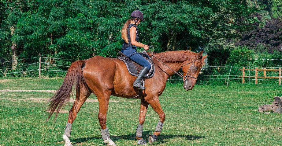 One woman riding a horse around 