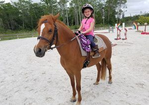 girl with a horse, looking at camera