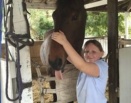 girl with a horse in stable