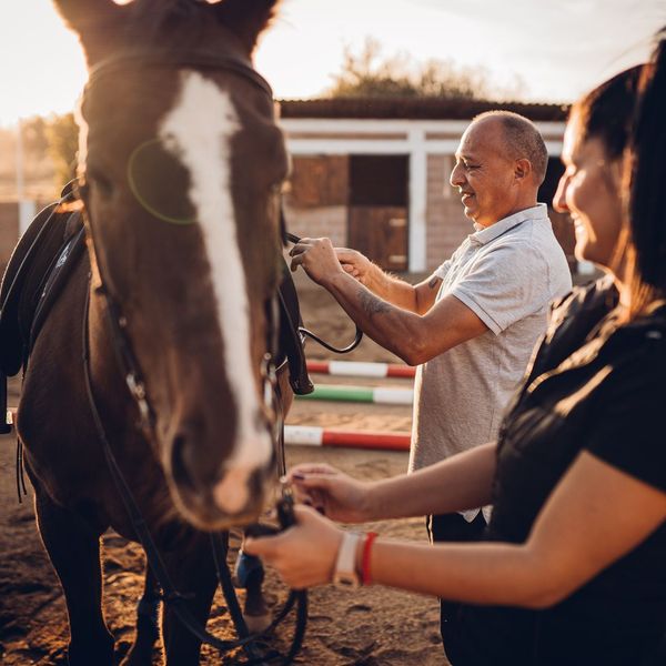 A horse trainer and student next to a horse