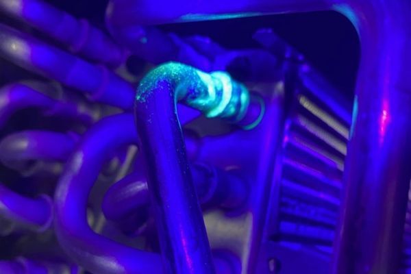 evaporator coil with a visible refrigerant leak being detected using a UV (Ultraviolet) light