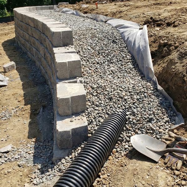 A cross-section view of a retaining wall being constructed