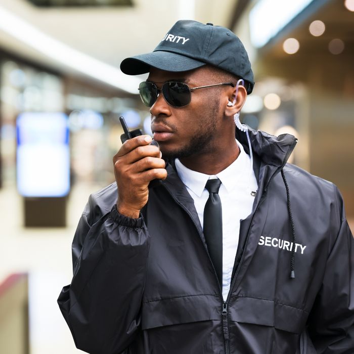 Male security guard talking into a radio