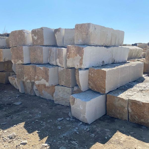 Large inventory of rough-hewn limestone blocks at the yard, perfect for contractors seeking wholesale rock supplies direct from the source.