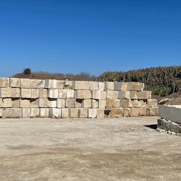 Massive inventory of rectangular limestone blocks stacked at the quarry, ensuring contractors have consistent access to landscape rock.