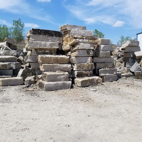 Neatly stacked rectangular limestone blocks, showcasing the premium quality landscape rock inventory available for retaining walls.