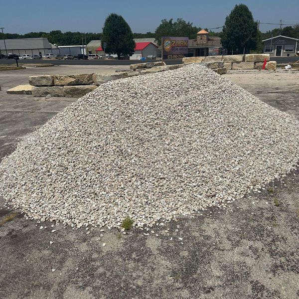 A large bulk pile of crushed limestone wholesale rock at the Ozark Stone Yard lot, ready for delivery.