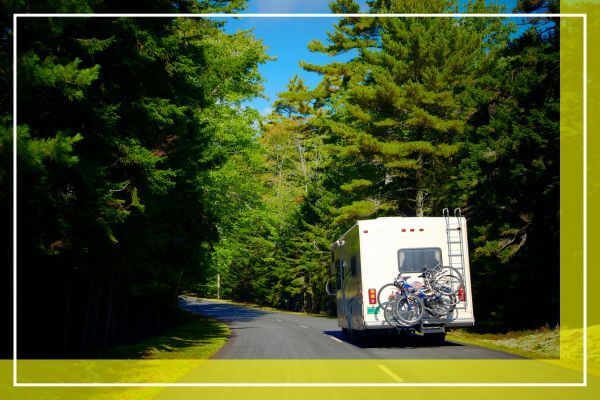 RV driving down wooded road