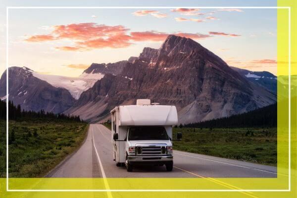 RV driving down a road with mountains in the background