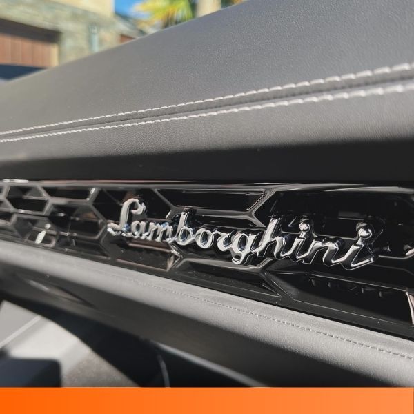 Close-up of the chrome Lamborghini script emblem on the rear of a vehicle.