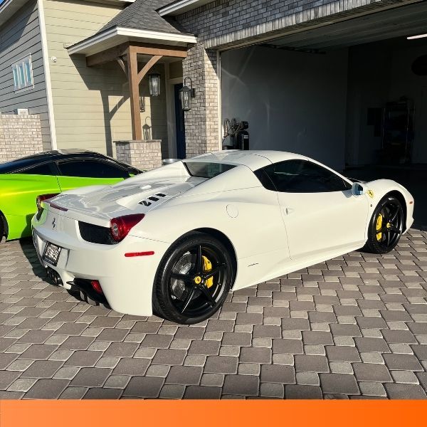Side profile of a white luxury sports car parked on a driveway.
