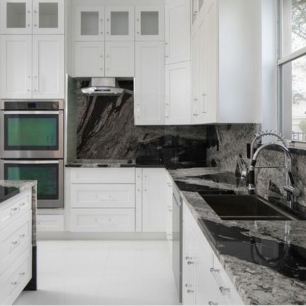 white kitchen cabinets with dark grey and black granite