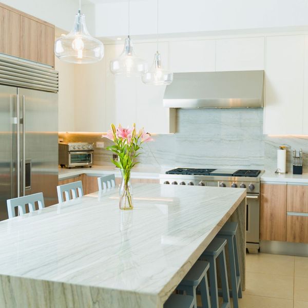 a luxury kitchen with light cabinets and marble countertops