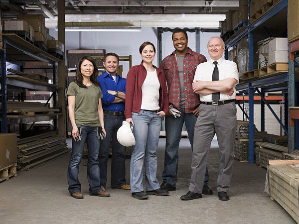 A group of construction workers standing together inside a warehouse