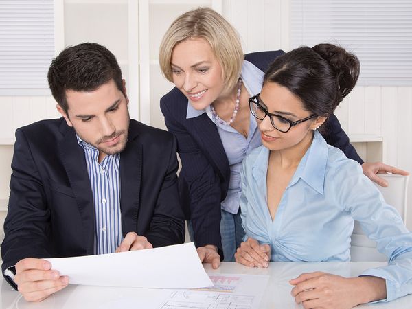 Image of 3 business people working together and looking at documents