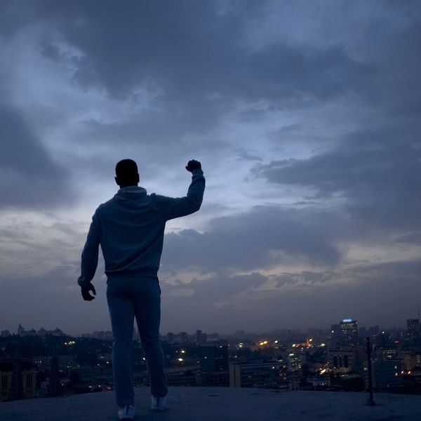 image of a man at the top of the hill flexing his bicep enjoying success