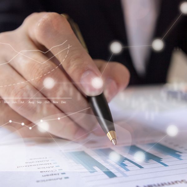 image of a man writing with a pen on a chart 