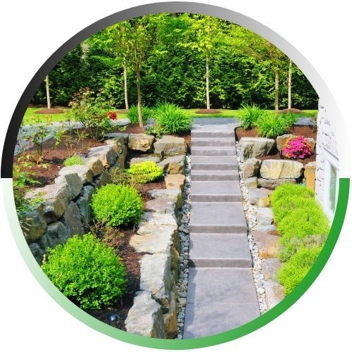 Circular icon of a modern backyard featuring stone retaining walls and a clean concrete staircase leading to a manicured garden.