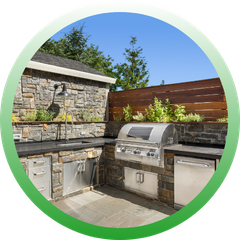 Circular icon showcasing a luxury stone outdoor kitchen with a high-end grill, stainless steel cabinets, and built-in herb planters.