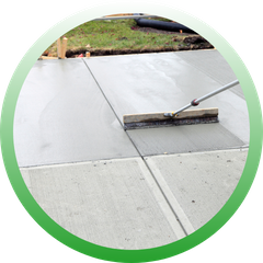 Circular icon showing a long-handled brush being used to finish the surface of a large, freshly poured concrete section.