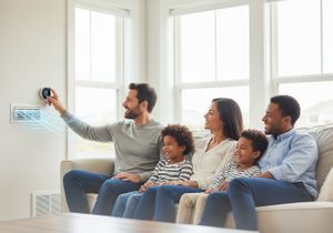 Family Adjusting Smart Home Thermostat