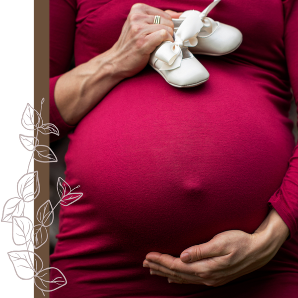pregnant woman holding baby shoes pregnant woman holding baby shoes
