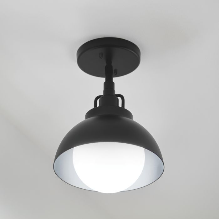 A product shot of a matte black, dome-shaped semi-flush mount utility light with a white globe bulb against a plain background.