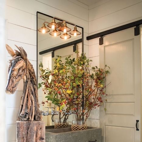 Rustic decor featuring a sliding mirror barn door, autumn foliage, and a carved wooden horse head.